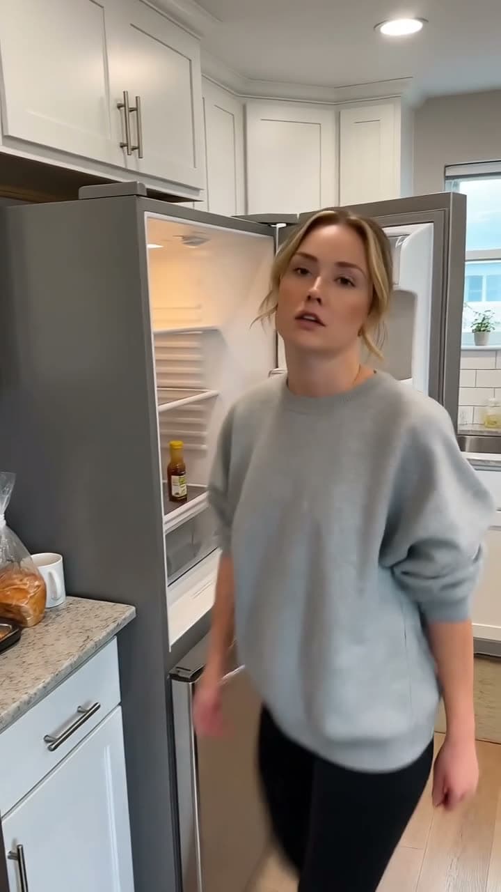 A vertical clip of a woman opening a fridge onto empty shelves and turning to camera with a raised eyebrow. Generated by HappyHorse 1.1 at native 9:16.